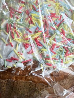 Buzlu Paska Paskalya pastasının dikey yakın çekimleri. Üstünde renkli şekerlemeler var.