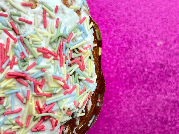 トップビューは スプリンクルと霜降り ピンクの輝きの背景とおいしいパスカイースターケーキのクロップアップ — ストック写真