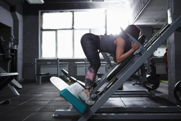 Unrecognizable Female Bodybuilder Exercising Hack Squat Gym Machine Copy Space — ストック写真