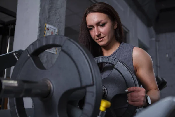 Sportswoman Adding Weights Leg Press Machine Her Workout — Foto de Stock