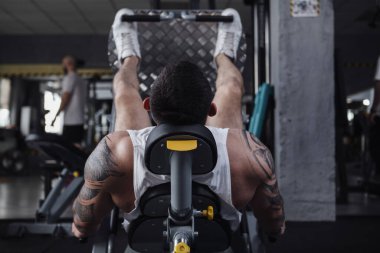 Rear view shot of unrecognizable male athlete doing leg press exercise