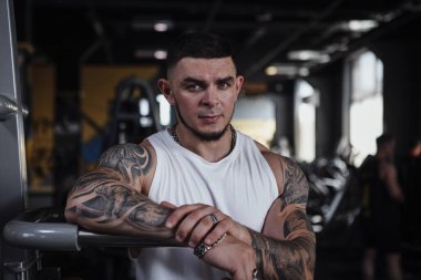 Handsome tattooed bodybuilder looking fiercely to the camera