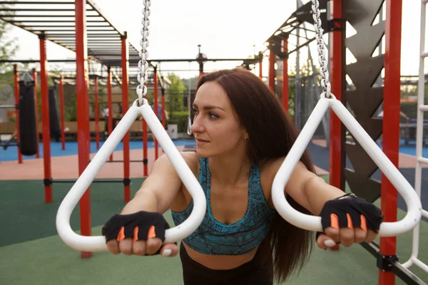 市内の屋外で体操リングの美しいスポーツ女性のトレーニング — ストック写真