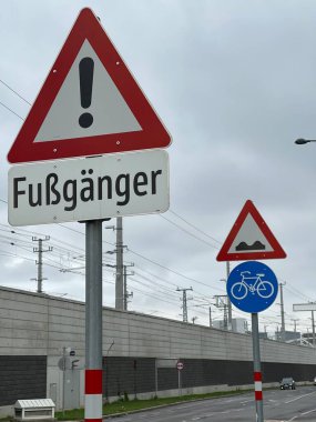 Kasvetli gri gökyüzünün altındaki trafik işaretinin dikey görüntüsü