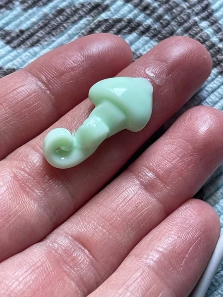 人間の指に緑の保湿クリームの垂直閉鎖 — ストック写真