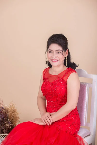 Piękne Azji Dorosłych Kobieta Czerwony Sukienka Siedzi Krzesło Pobliżu Kwiaty — Zdjęcie stockowe