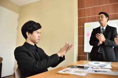 Ofiste çalışırken el ele tutuşan iş adamları.