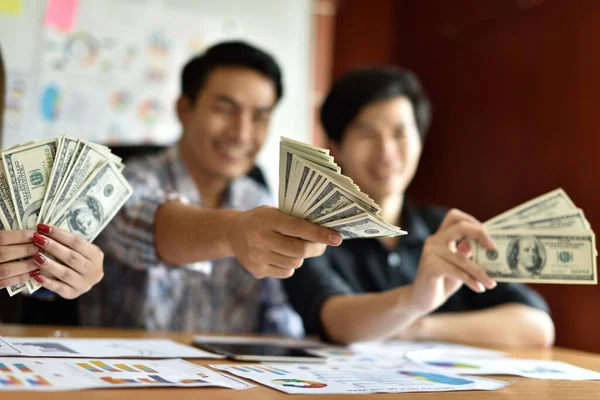 Ofisinde dolar banknotları olan Asyalı işadamları