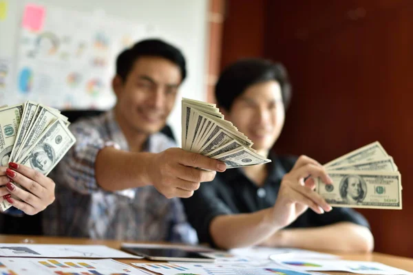 Ofisinde dolar banknotları olan Asyalı işadamları