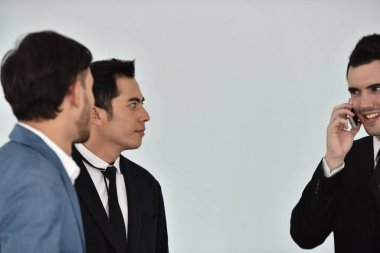 İş ortakları cep telefonuyla konuşuyor ve tartışıyorlar.