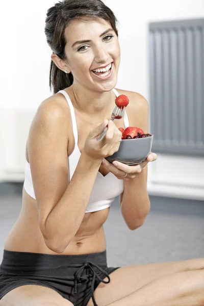 Donna ieating frutta in abiti fitness — Foto Stock