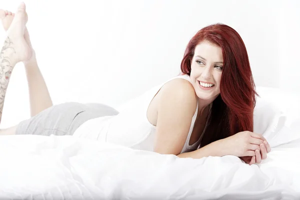 Kvinnan som ligger på sängen — Stockfoto