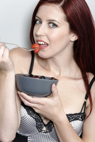 Woman eating fruit in underwear — Stock Photo, Image