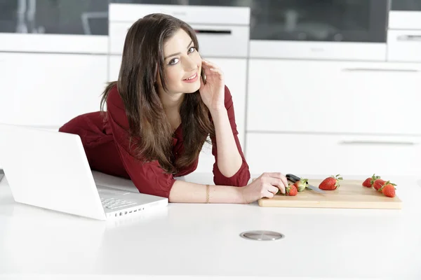 Woman in kitchen reading recipe — Stock Photo, Image