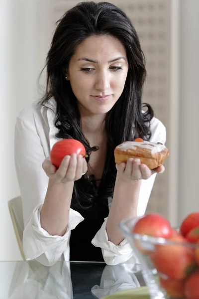 Frau wählt Kuchen oder Obst — Stockfoto