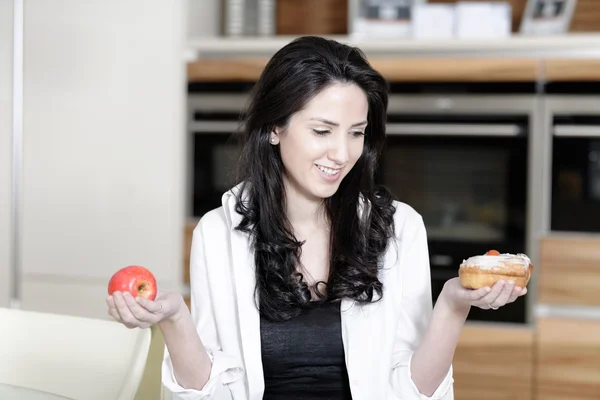 Frau wählt Kuchen oder Obst — Stockfoto