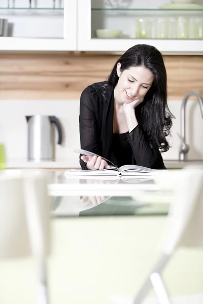 Woman reading recipe book — Stock Photo, Image