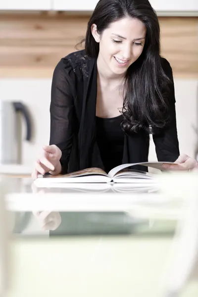 Mulher leitura livro de receitas — Fotografia de Stock