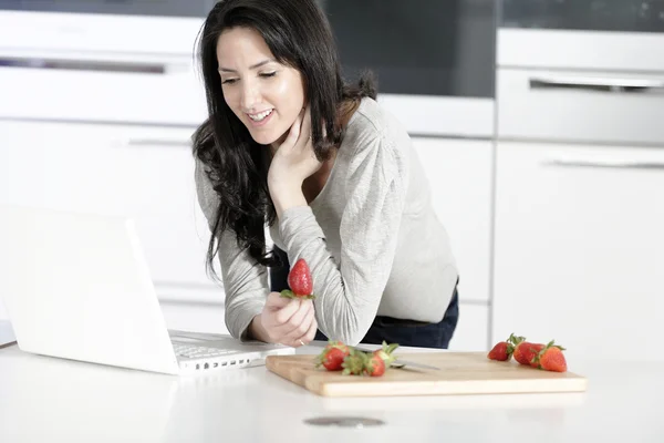 Frau in Küche liest Rezept — Stockfoto