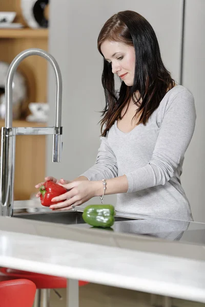 Kobieta płukania papryki w umywalkę — Zdjęcie stockowe