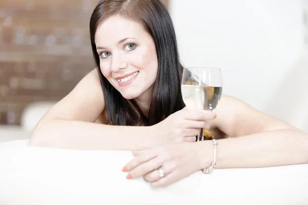 Kadın rahatlatıcı bir içecek ile onun Divan — Stok fotoğraf
