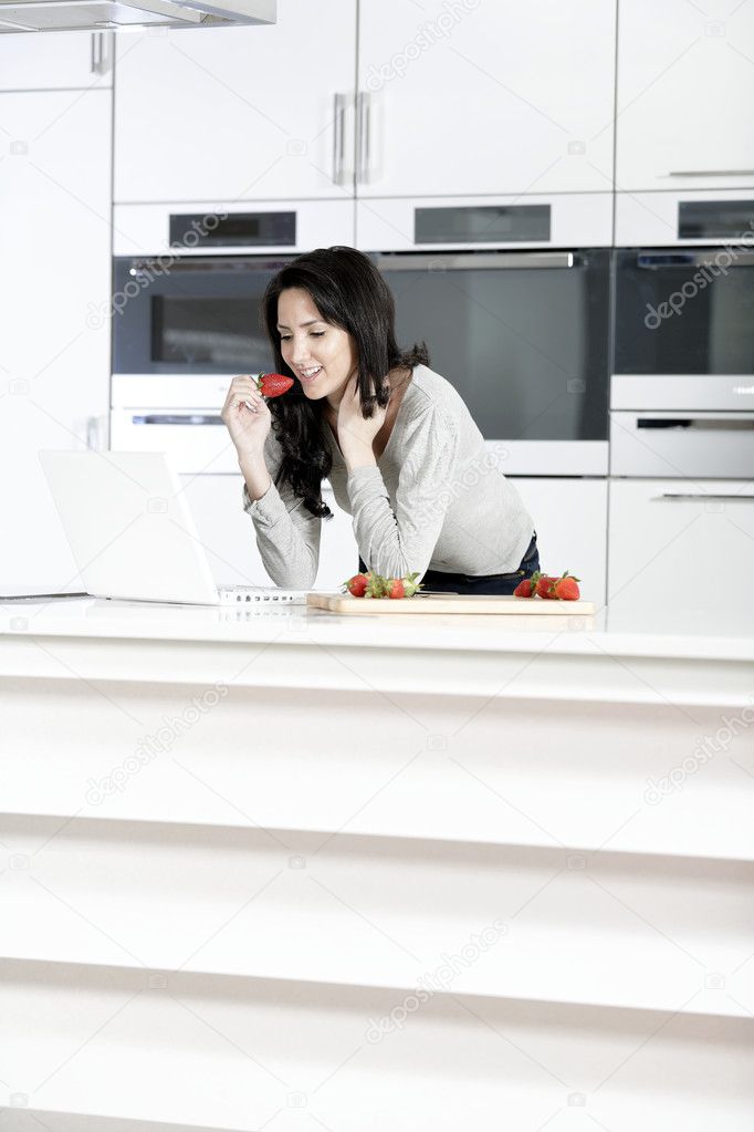 Woman in kitchen reading recipe