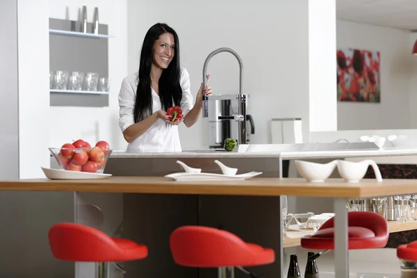 Donna che risciacqua peperoni in un lavandino — Foto Stock