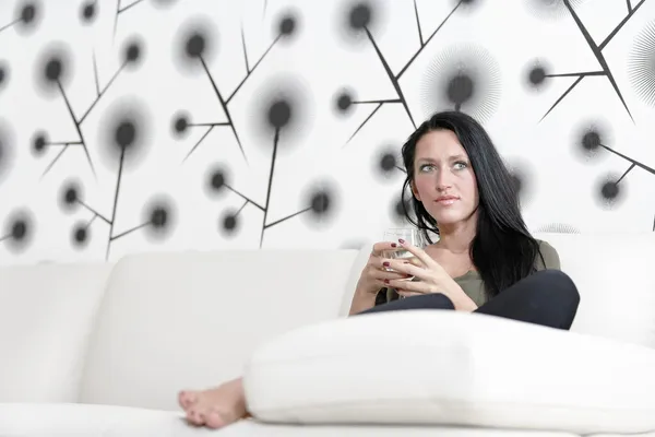 Femme relaxante sur son canapé avec un verre — Photo