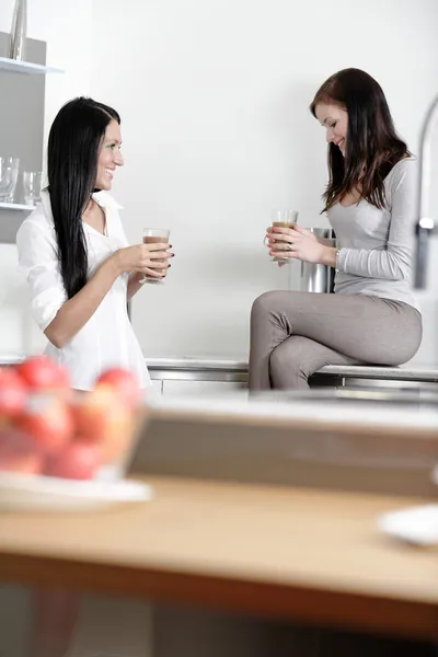 Two friends catching up in the kitchen — Stok fotoğraf