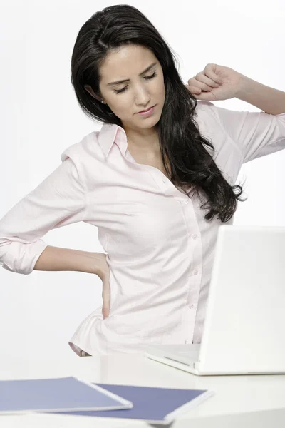 Frau mit Rückenschmerzen am Schreibtisch — Stockfoto