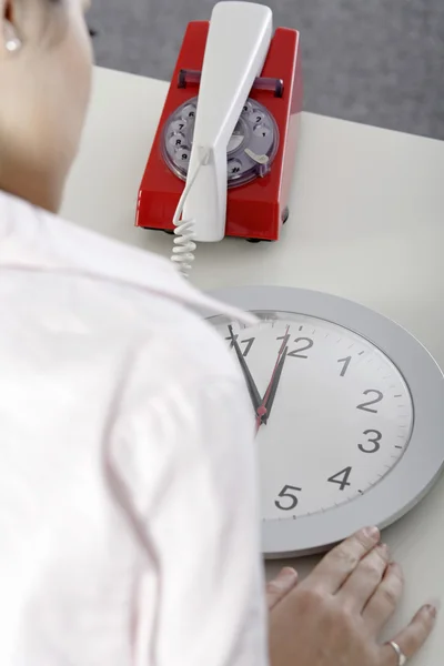 Femme attendant près d'une horloge — Photo