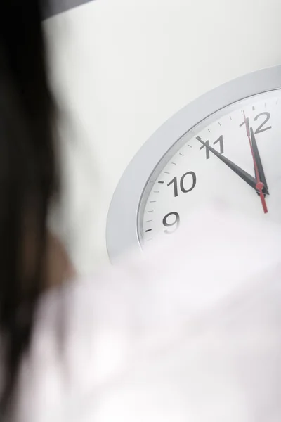 Femme attendant près d'une horloge — Photo