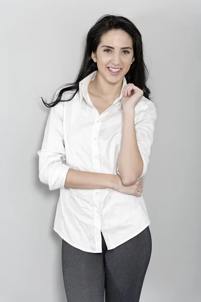 Woman in white shirt leaning against wall — Stock Photo, Image