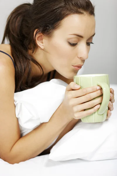 Frau trinkt im Bett — Stockfoto