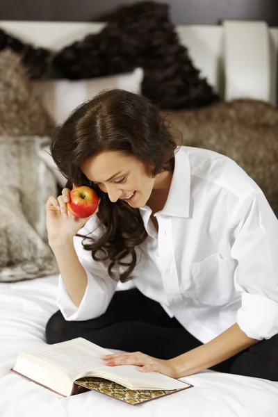 Woman reading book in bed — Stock Photo, Image