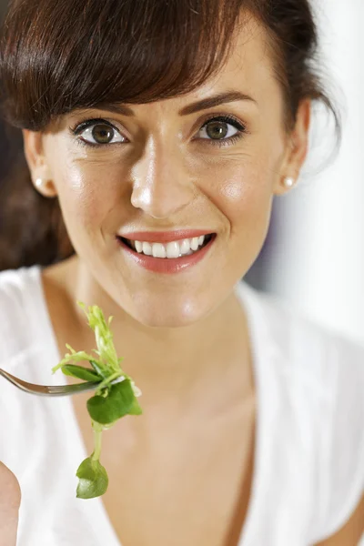 Kvinde spiser salat derhjemme - Stock-foto