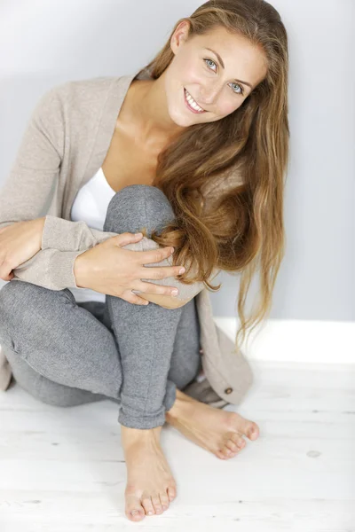 Femme assise appuyée contre le mur — Photo