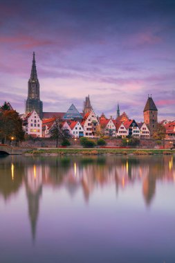 Ulm, Almanya. Ulm Minster ile Almanya 'nın Ulm kentinin şehir manzarası, dünyanın en uzun kilisesi ve sonbahar günbatımında Tuna Nehri' ndeki şehrin yansıması..