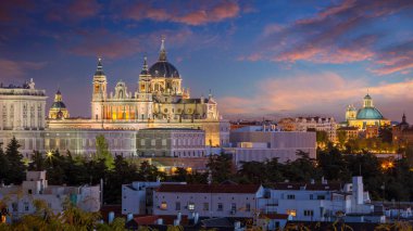 Madrid, İspanya. Madrid 'in panoramik şehir manzarası Santa Maria la Real de La Almudena Katedrali ve alacakaranlıktaki Kraliyet Sarayı ile gökyüzü.