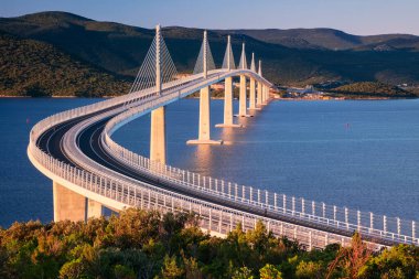 Peljesac Köprüsü, Hırvatistan. Hırvatistan 'ın Dubrovnik-Neretva İlçesi' nde güneş doğarken deniz üzerindeki Peljesac Köprüsü 'nün çok açıklıklı güzel bir görüntüsü.