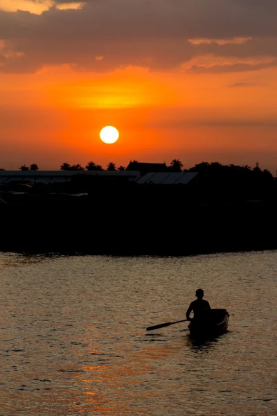 Adam gün batımında tekne kürek — Stok fotoğraf