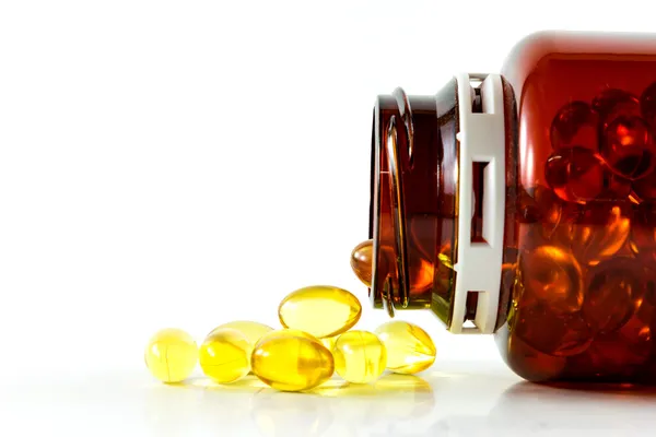 Balık yağı kapsülleri yatay şişesinden döktü