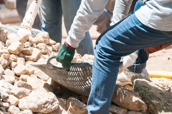 Рабочие перемещают камни для строительства — стоковое фото