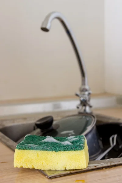 Чистая губка и кухонные принадлежности в раковине — стоковое фото