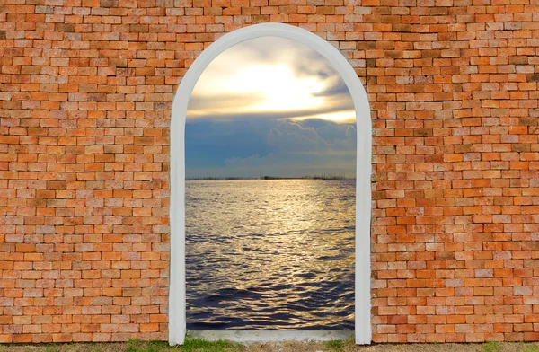 Ingresso all'oceano di porta su parete mattone cielo crepuscolo — Foto Stock