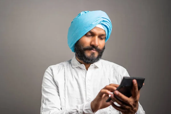 Studioaufnahme Eines Jungen Sikh Mannes Der Ernsthaft Über Steuern Oder — Stockfoto