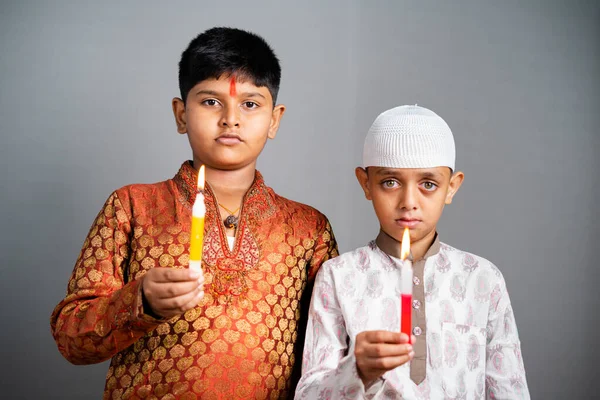 Индуистские мусульманские дети скорбят или молятся, держа свечи, глядя в камеру - концепция отдачи дани и защиты нового религиозного коммунизма. — стоковое фото