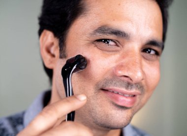 Yakışıklı adamın cilt bakımı ya da cilt bakımı, sivilce yaraları ve yüz masajı gibi cilt kremi kullanırken yakın plan çekimleri..