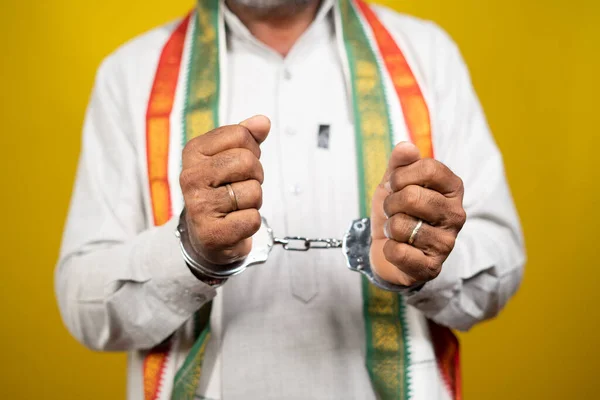 Nierozpoznany przestępca indyjski polityk z kajdankami na żółtym tle - koncepcja zbrodni politycznej, aresztowany przywódca polityczny i uwięziony w polityce — Zdjęcie stockowe