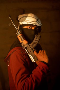 Gangster 'ın silah zoruyla çekilmiş bir portresi. Terk edilmiş bir yerde kameraya bakıyor. Suçlu ve silahlı hırsız kavramı.